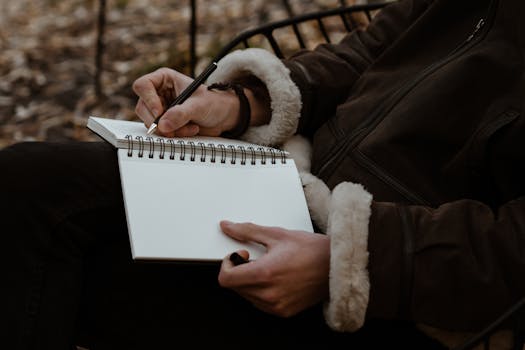 man writing in a journal