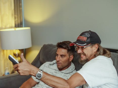 older man laughing while watching television